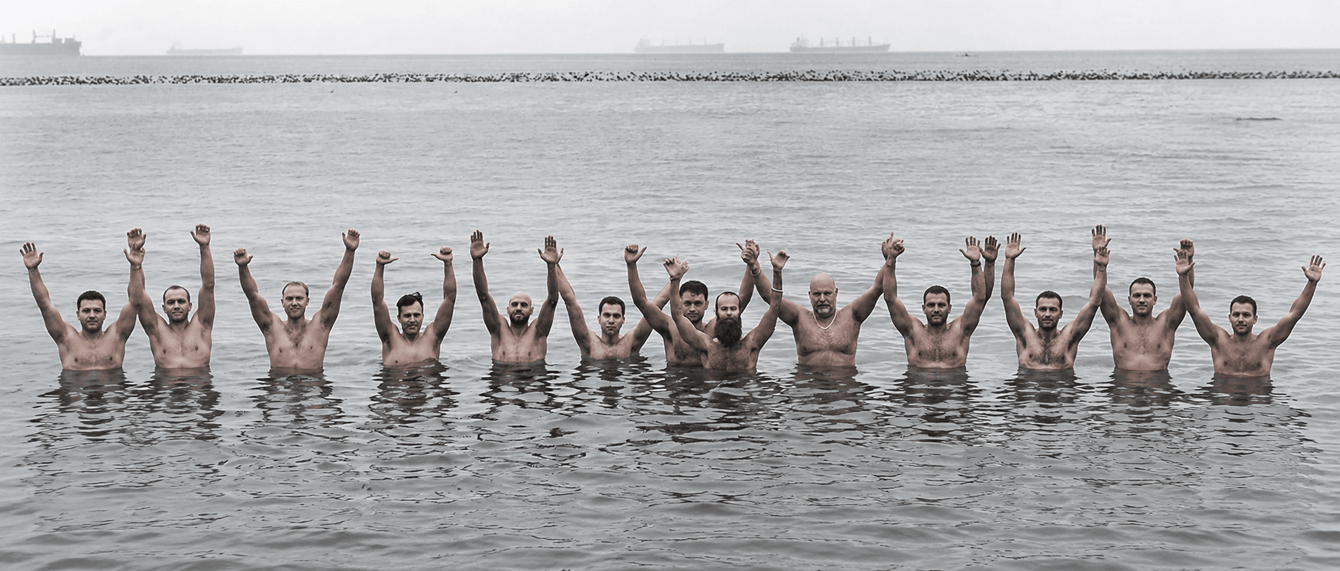 Will Blunderfield leading men with hands raised in the water
