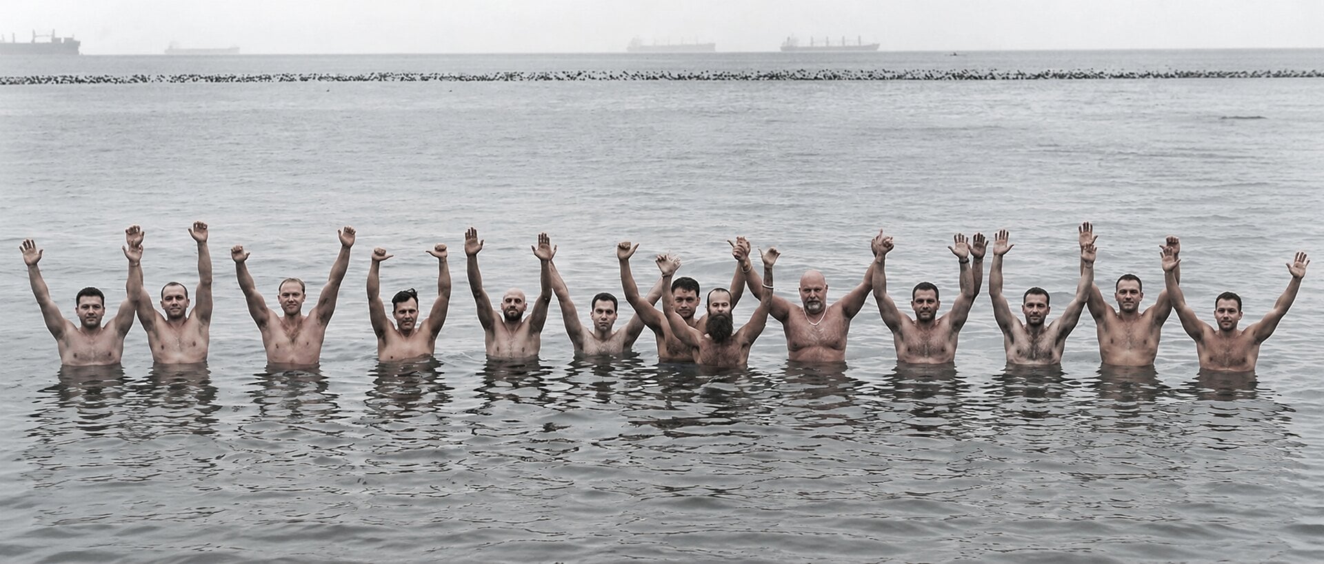 Will Blunderfield leading men with hands raised in the water